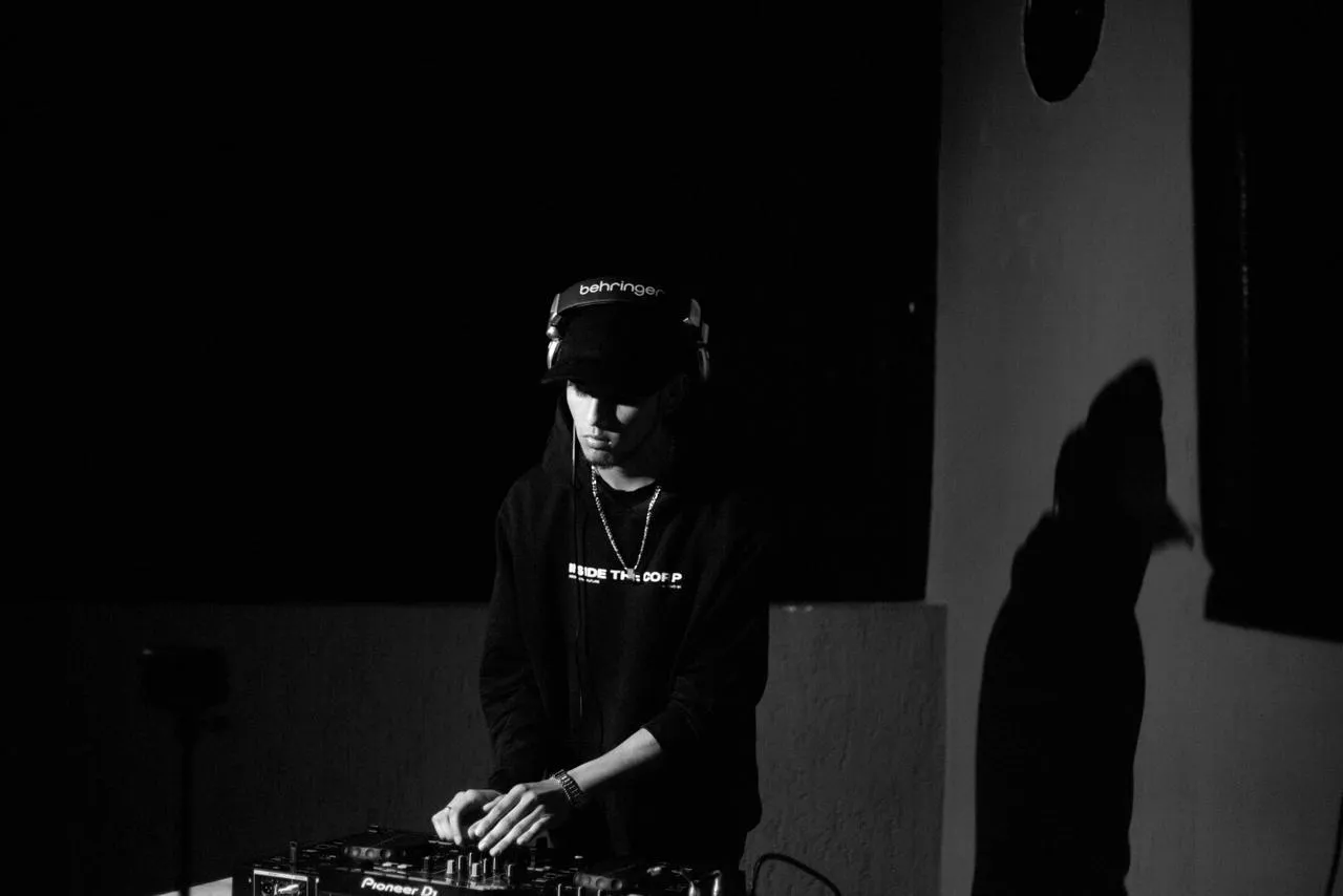 DJ con auriculares detrás de la mezcladora